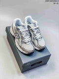 Pair of white, silver, and navy New Balance 740 sneakers displayed on a shoebox.
