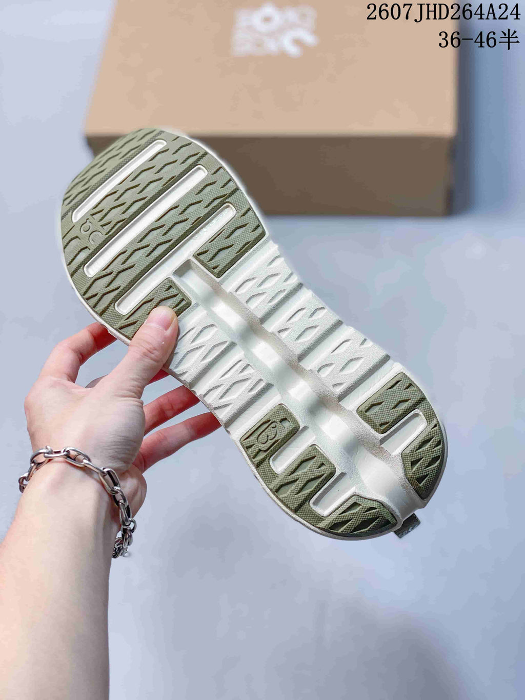 Close view of the sneaker outsole showing olive traction sections, white channels, and textured tread.