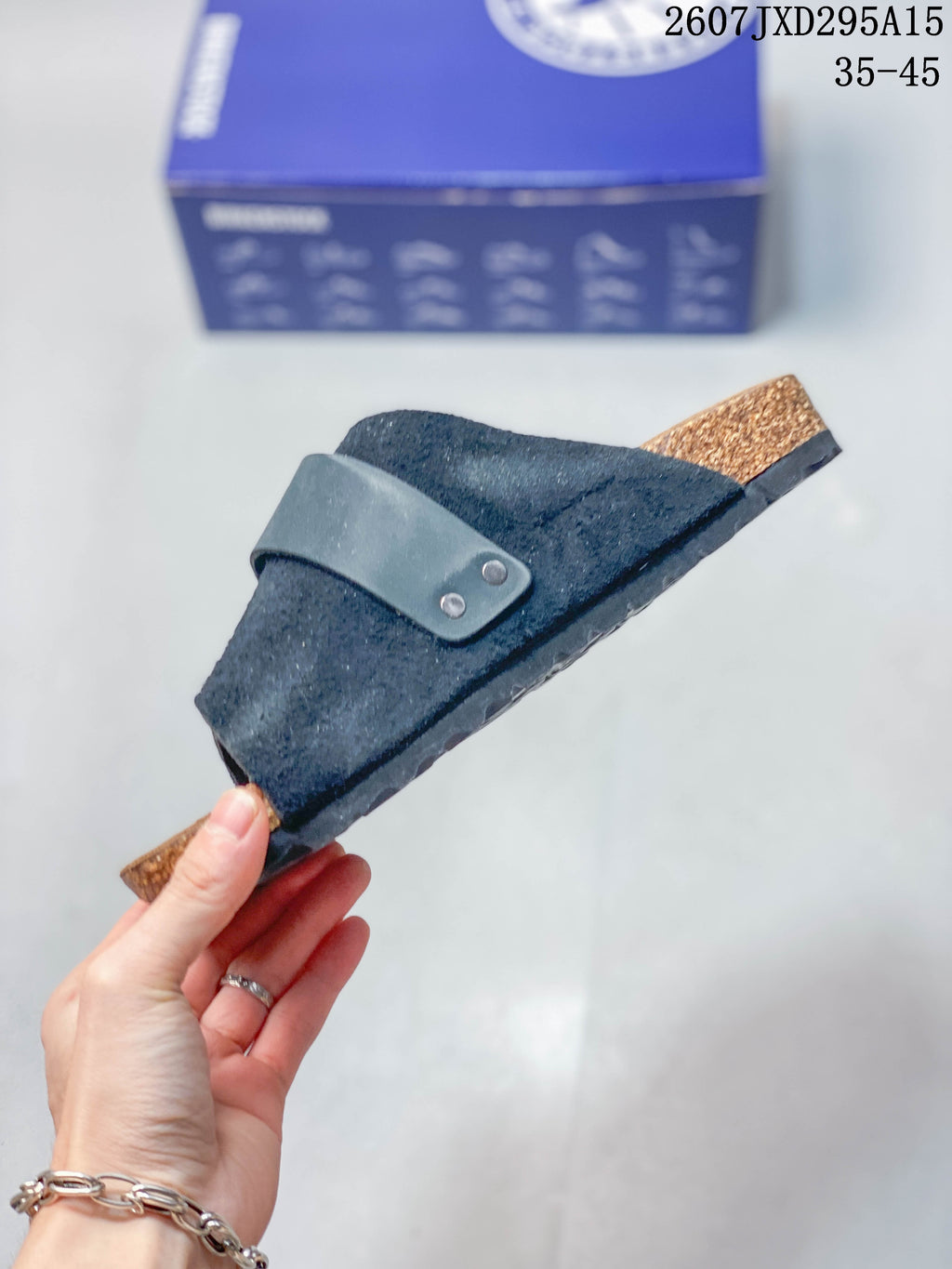 Side view highlighting the crossover upper, adjustable strap, cork-look footbed edge and textured outsole.