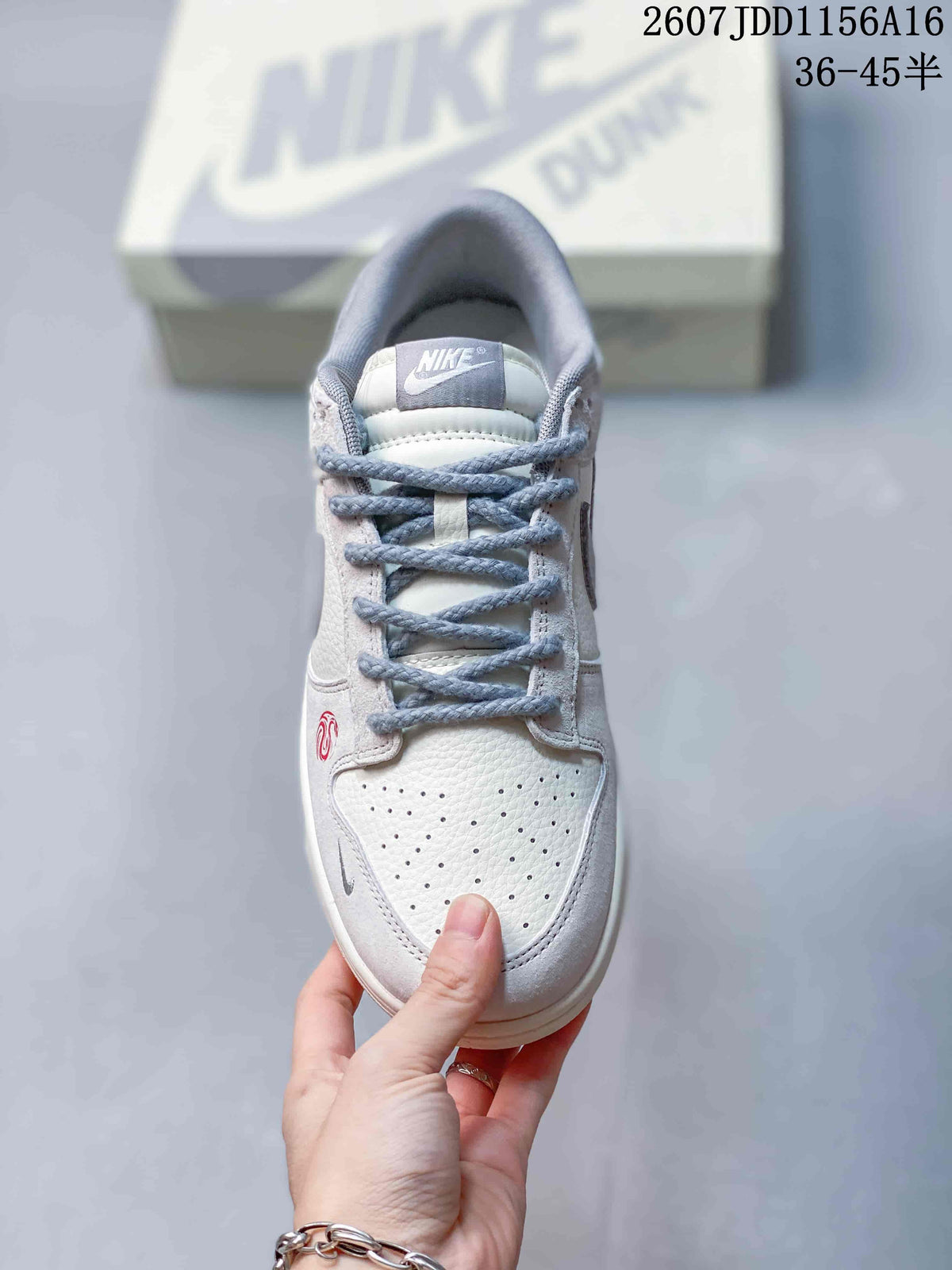 Top view of an off-white and grey Nike SB Dunk Low sneaker showing the perforated toe box, laces and tongue branding.