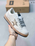 Close-up of a white Golden Goose Ball Star sneaker with a metallic gold star and gray branded laces.
