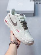 White Nike Air Force 1 '07 LV8 sneaker with brown Swoosh, pink accent and light outsole.
