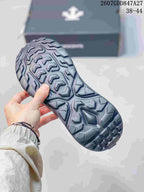 Underside view showing the sneakers' deep, geometric outsole tread.