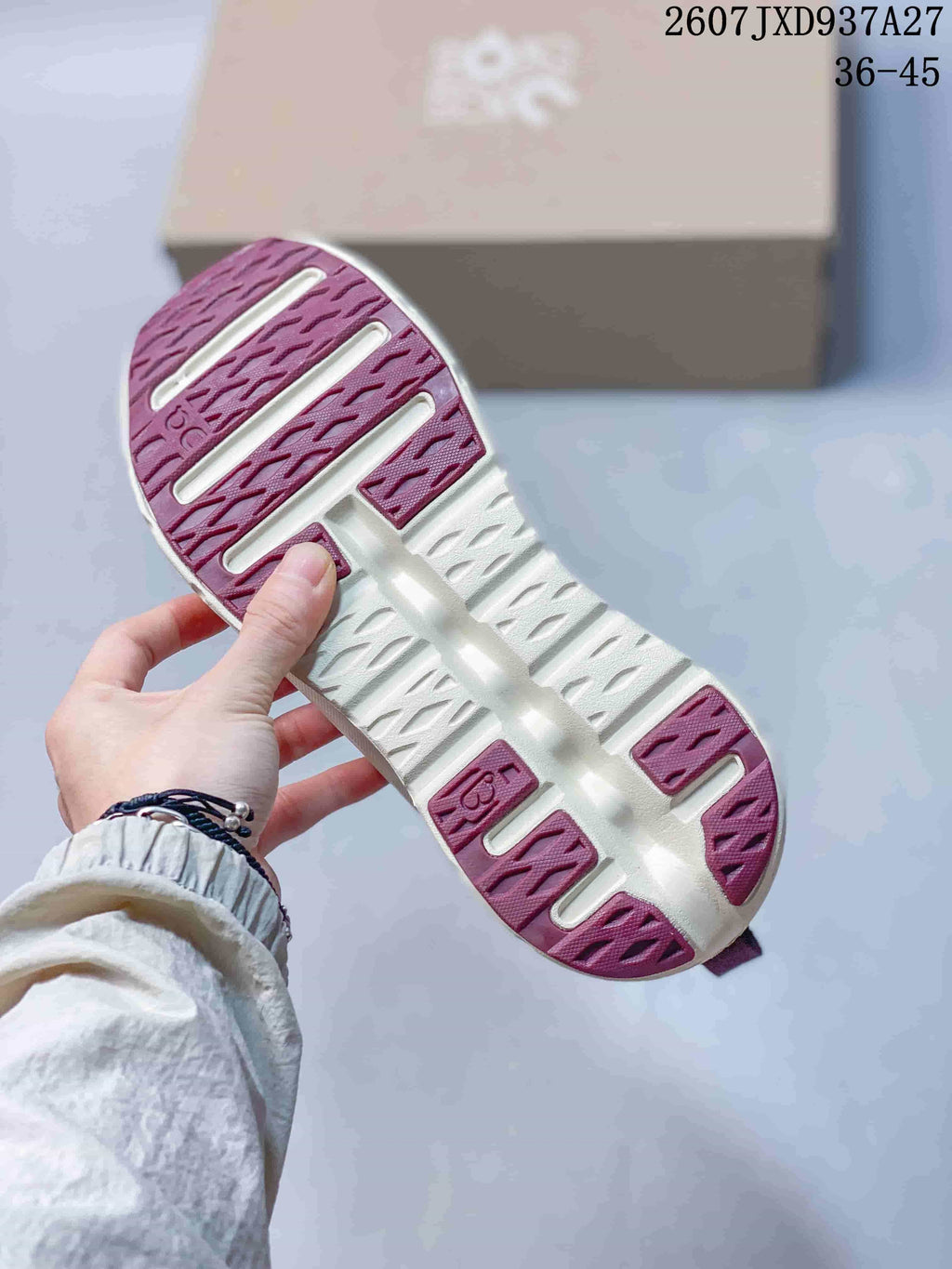 Underside view showing the white and burgundy segmented outsole pattern.