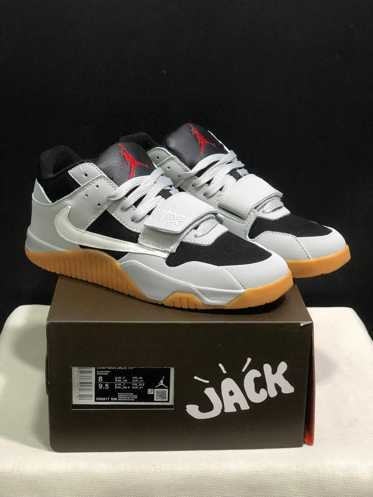 Pair of black and white Jordan Jumpman Jack sneakers displayed on a branded shoe box; the box label shows a photographed sample in EU 41.