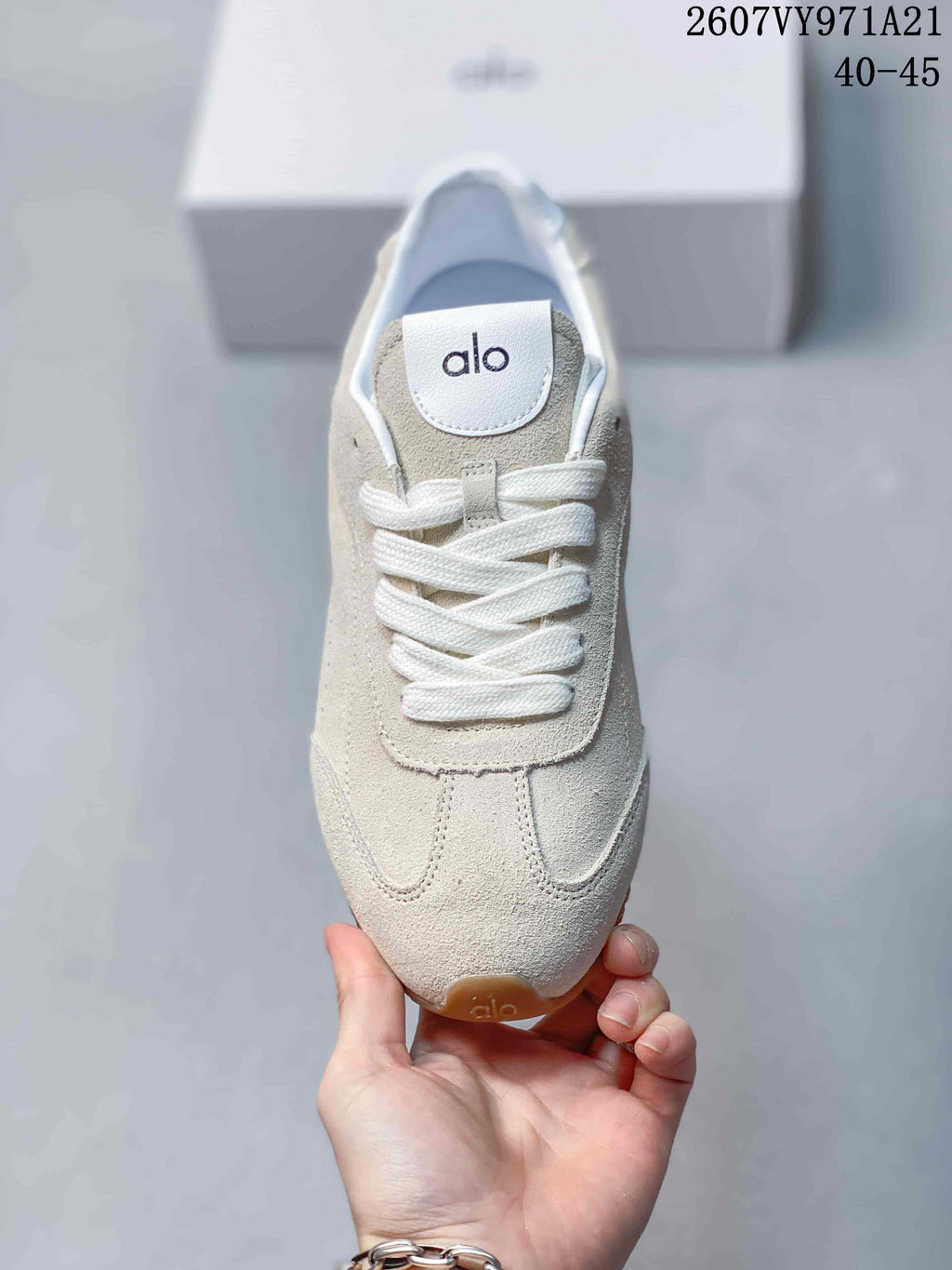 Top view of the beige sneaker showing the white laces, tongue panel, toe stitching and Alo branding.
