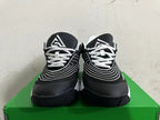 Front view showing white laces and curved white detailing on black Nike sneakers