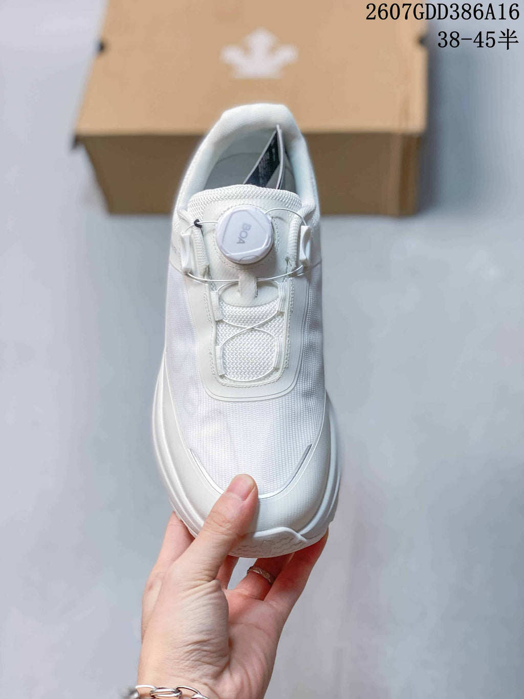 Top view of a white sneaker showing the textured upper, structured lace area, and round BOA dial closure.
