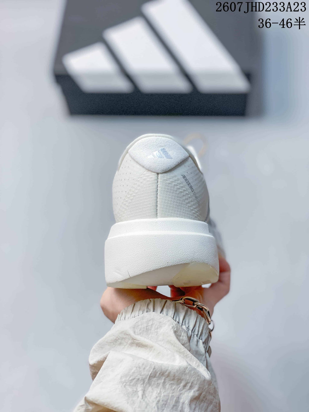 Rear view of the white sneaker showing the padded heel, textured upper, and thick sole.
