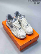 Pair of cream and gray patterned low-top sneakers on an orange box