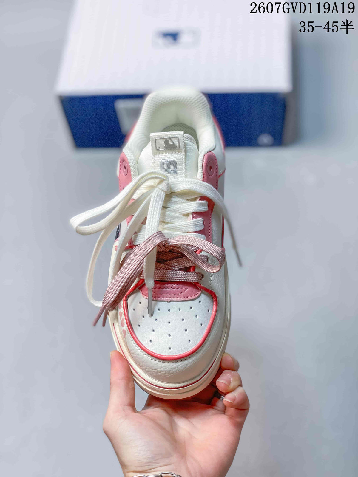 Top view of the sneaker showing the perforated toe panel, white and pink trim, and two contrasting lace colors.