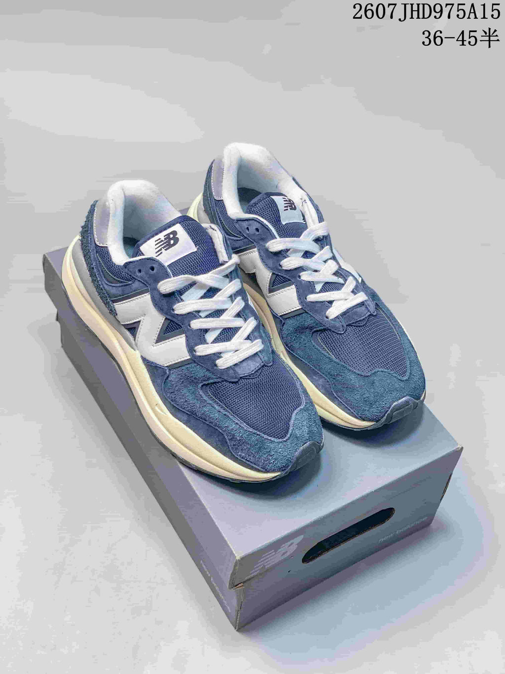 Pair of navy and white New Balance 5740 sneakers displayed on a shoebox.