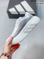 Side view highlighting the layered grey and white upper and textured sole.