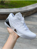 White Nike Kobe low-top basketball shoe with black textured heel accents, shown from the lateral side.