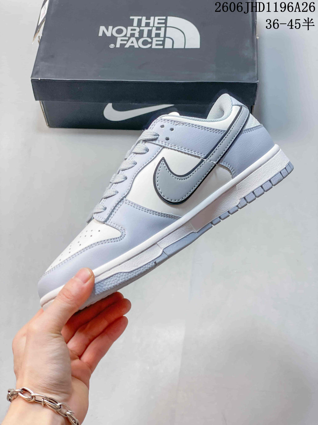 Side view of a white and light gray low-top sneaker with contrasting Swoosh detail.