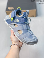 Angled side view showing The North Face branding, adjustable straps, lace-style fastening, and light outsole.