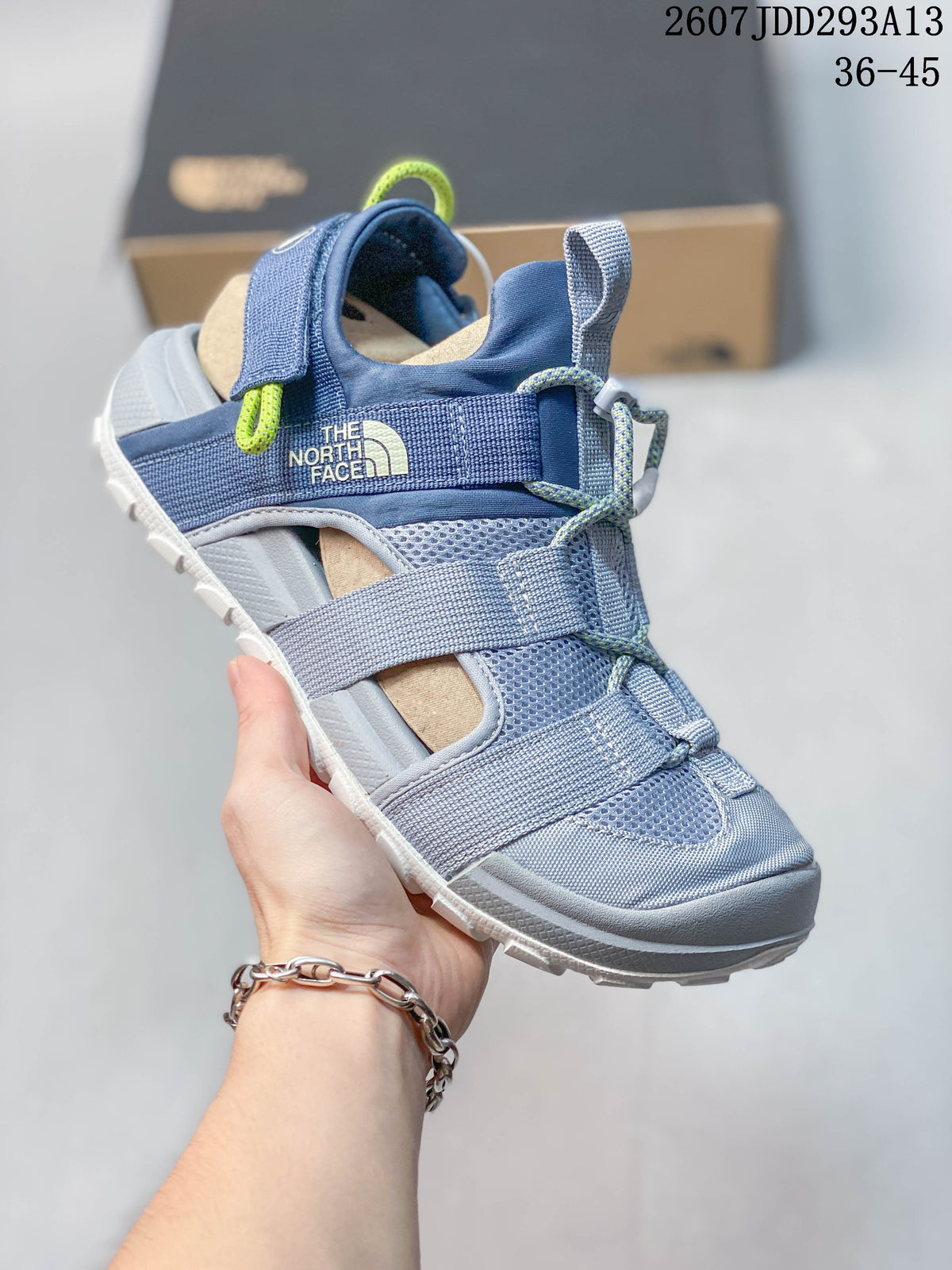 Angled side view showing The North Face branding, adjustable straps, lace-style fastening, and light outsole.