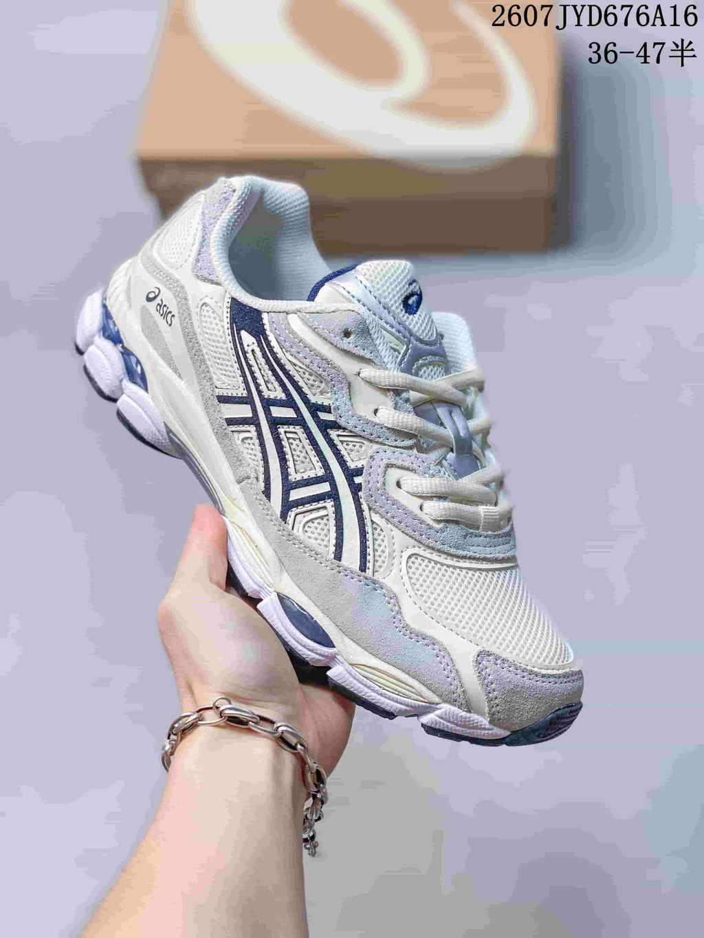 Angled side view of the ASICS GEL-NYC sneaker showing the layered upper, navy side logo and textured outsole.