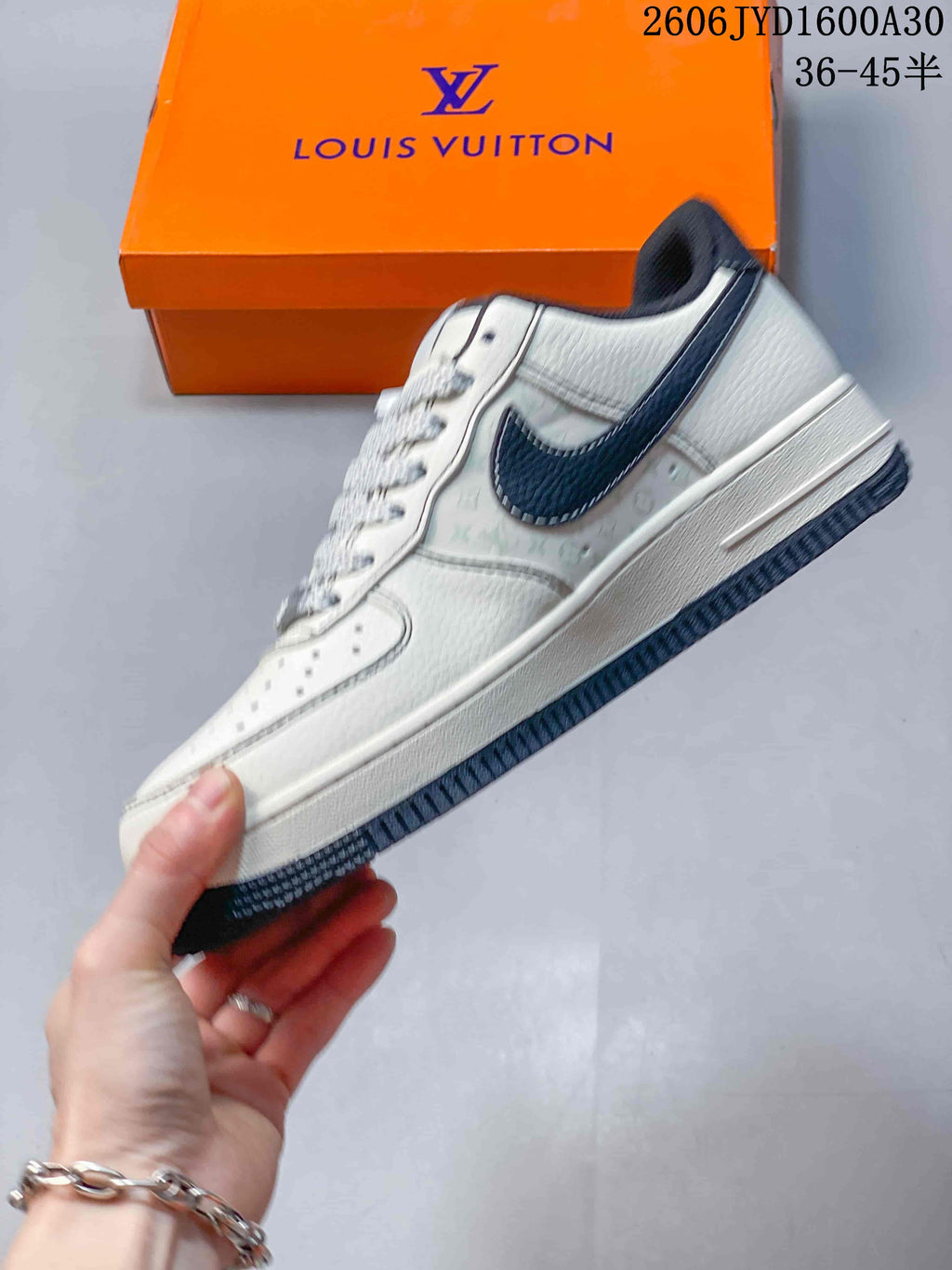 Side view of the white low-top sneaker with a dark swoosh and patterned side panels