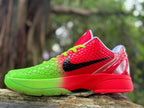 Close side profile of a red and green shoe with black Swoosh and textured upper