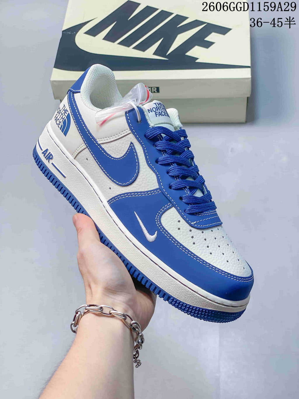 Angled view of the white and blue sneaker showing the side swoosh, heel branding, and blue outsole.