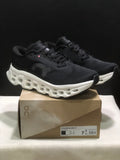 Pair of black and white On Cloudmonster 3 sneakers displayed on a branded shoe box.