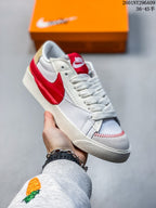 White Nike Blazer Low ’77 Jumbo sneaker with a red Swoosh and red tongue