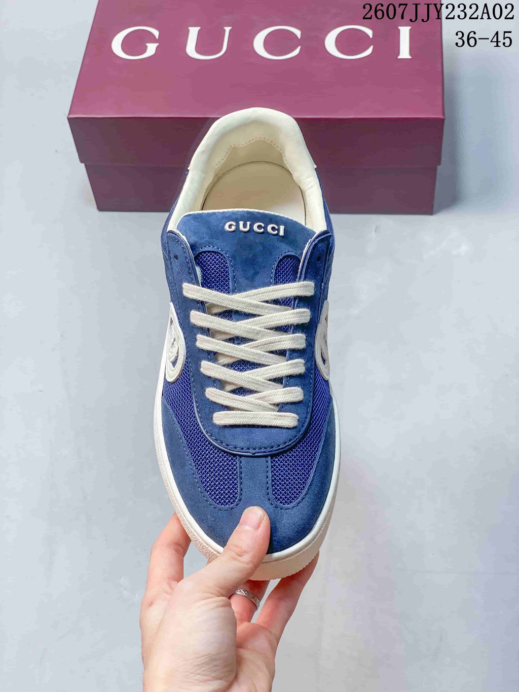 Top view of a blue low-top sneaker with white laces and mesh panels