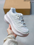 Angled side view of a white sneaker showing the mesh upper, layered overlays, lace loops and thick white sole.