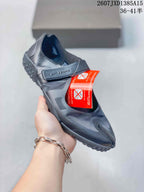 Angled side view of a black Nike Air Rift split-toe shoe showing the strap, upper panels, and textured sole.