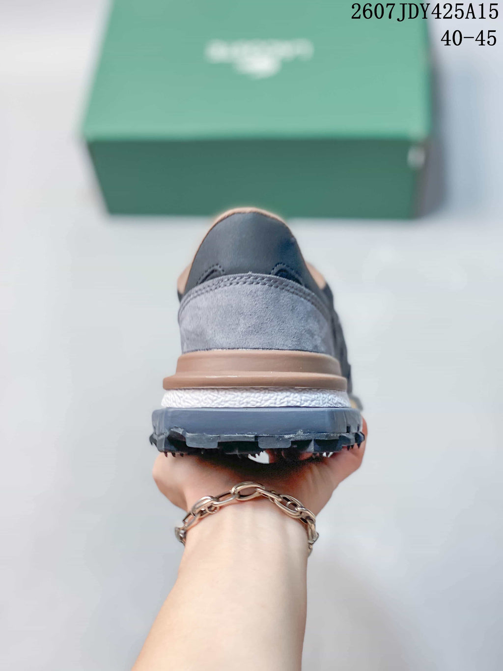 Rear view of a gray Lacoste sneaker showing the layered heel, white midsole, and dark outsole.