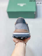 Rear view of a gray Lacoste sneaker showing the layered heel, white midsole, and dark outsole.