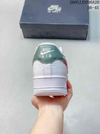 Rear view of the sneaker showing the green heel panel, white layered upper, Air branding, and textured white outsole.