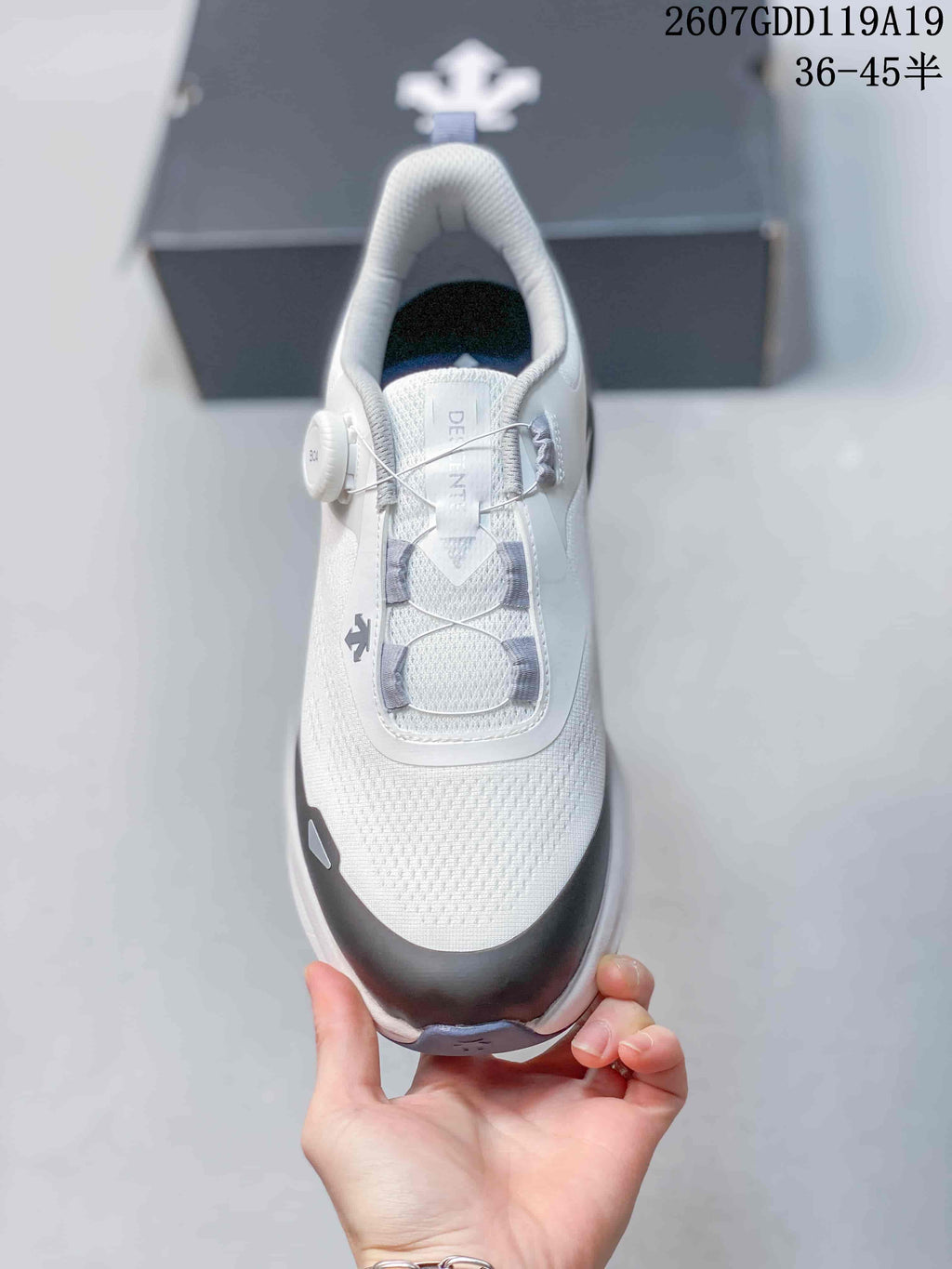 Top view of the white shoe showing the mesh-textured toe, gray cable lacing, BOA-style dial, and padded collar.
