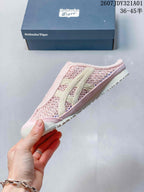 Side view of a pink openwork slip-on with cream-colored stripes and a textured light outsole.