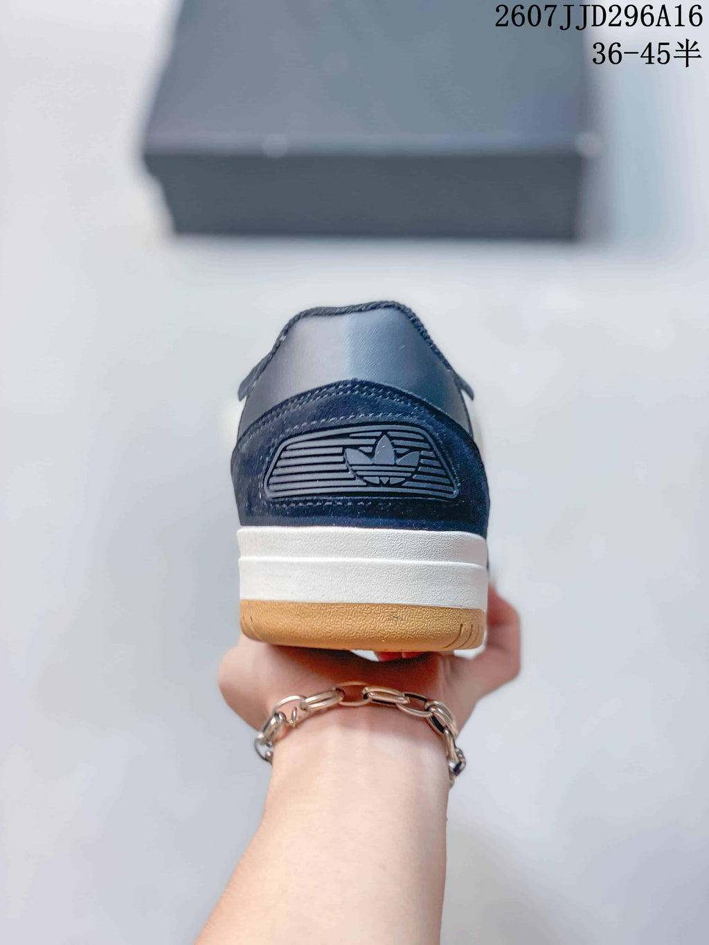 Rear view of the sneaker showing the navy heel panel, trefoil detail, white midsole, and gum-colored outsole.
