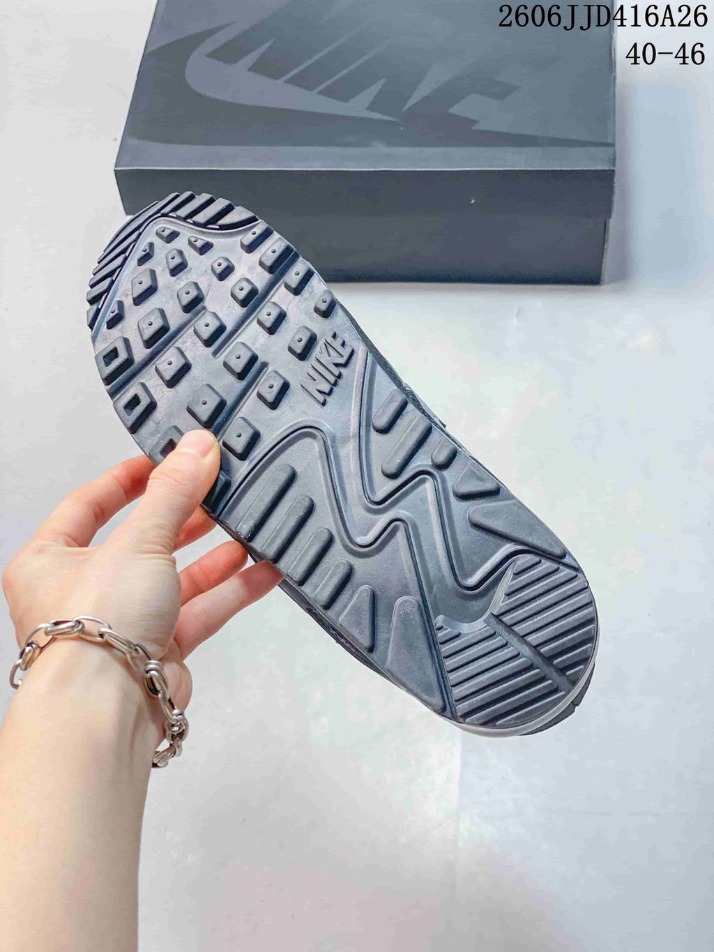 Close view of the patterned gray outsole with raised traction lugs and visible Nike branding.