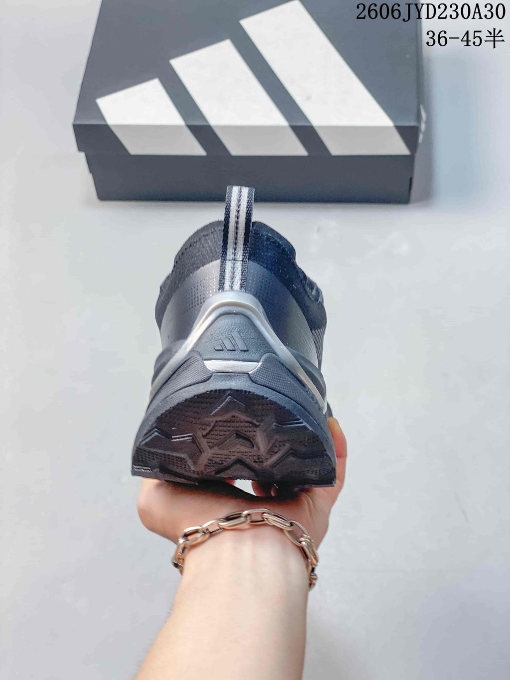 Rear view showing the heel pull tab and outsole of a gray Adidas shoe