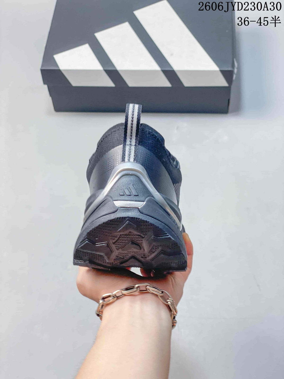 Rear view showing the heel pull tab and outsole of a gray Adidas shoe