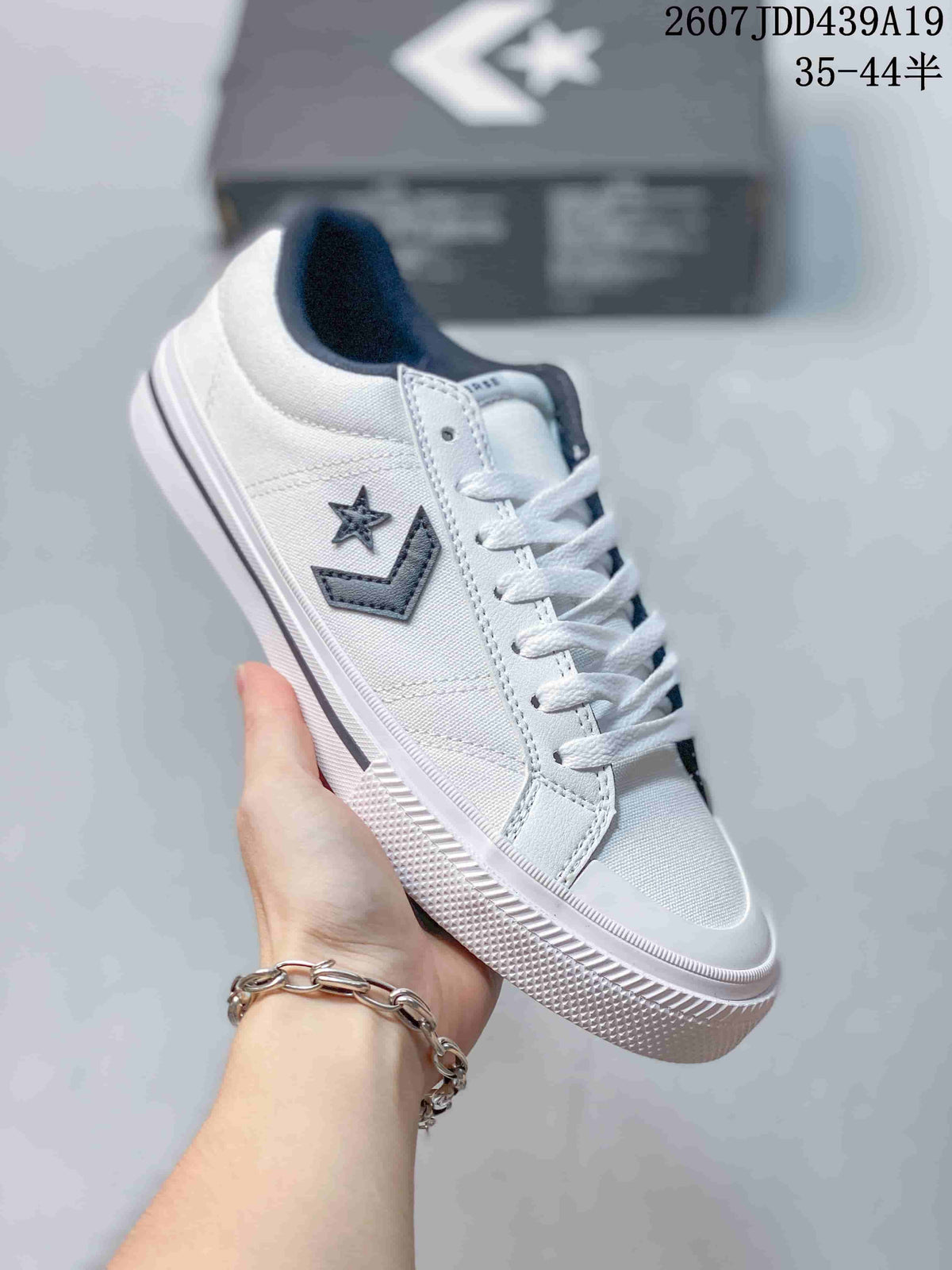 Close-up side view of a white Converse low-top sneaker showing the star-and-chevron logo, white laces and textured rubber outsole; image text shows size range 35–44.5.
