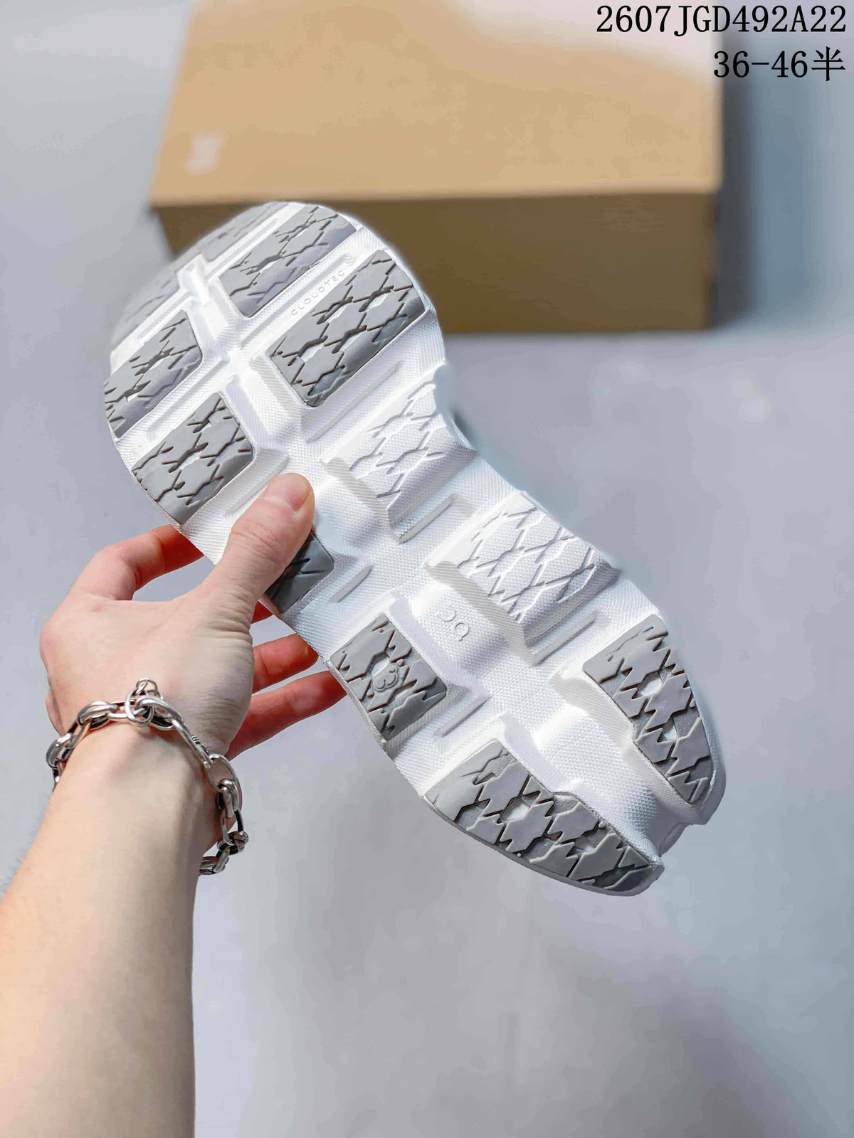 Underside view showing the segmented white outsole with gray patterned traction sections.