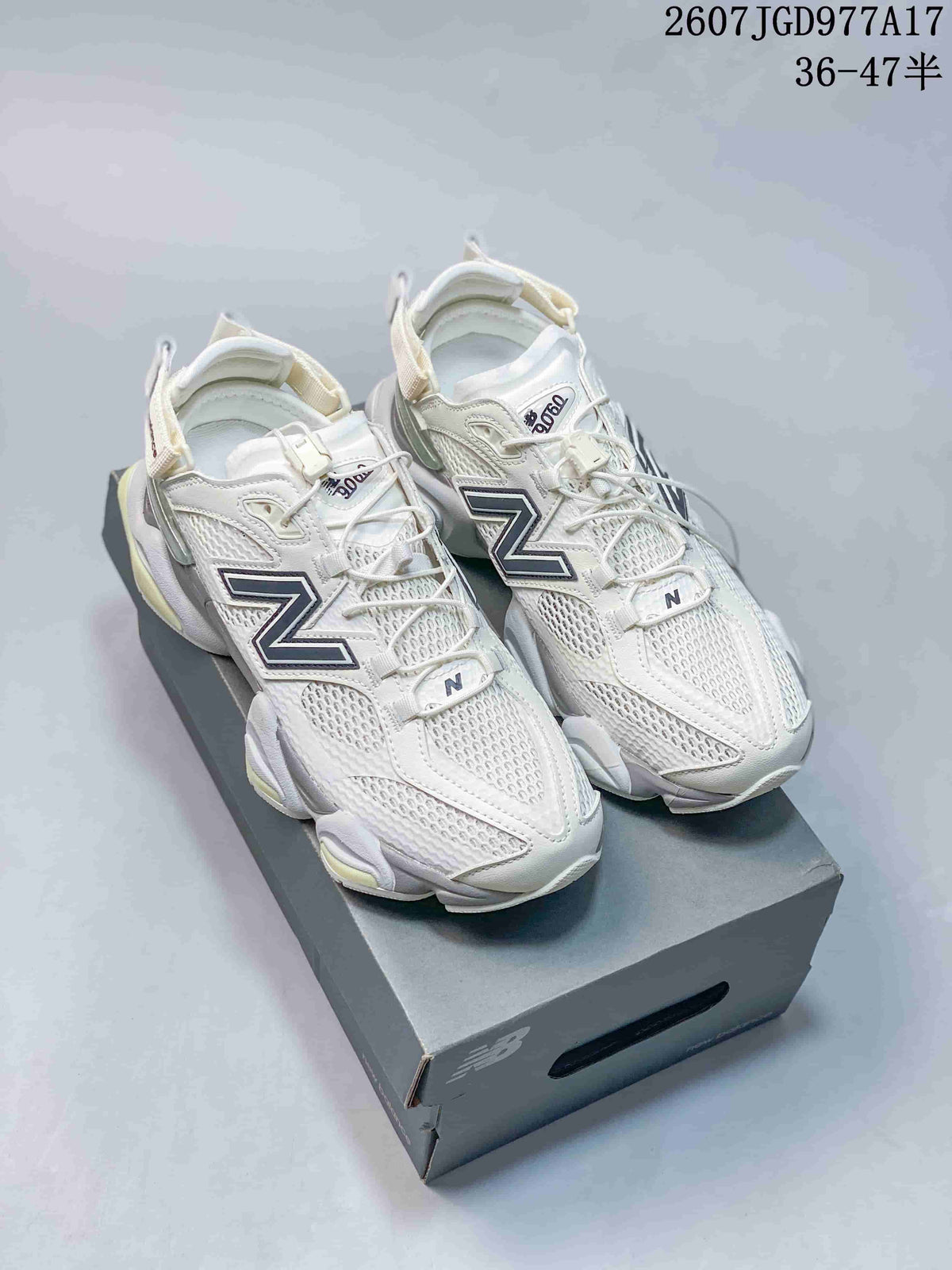 Pair of white New Balance 9060-style mule sneakers displayed on a shoe box, with navy branding and pale yellow-green accents.