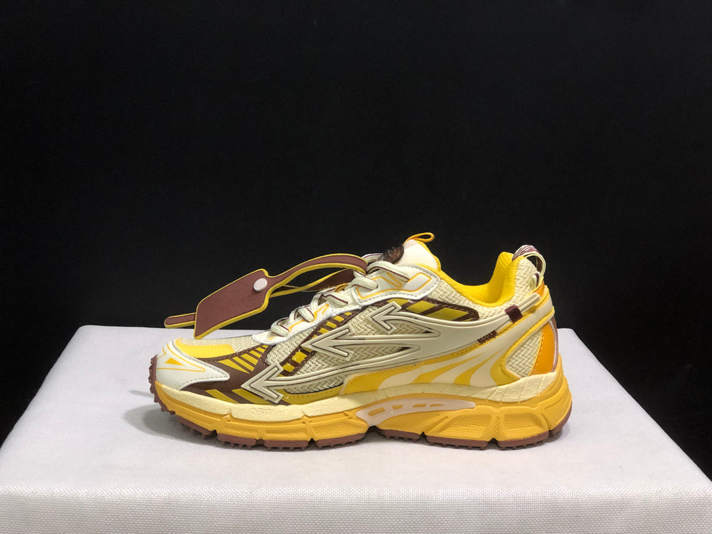 Lateral side view showing the layered arrow-shaped side detail, mesh paneling, and yellow outsole.
