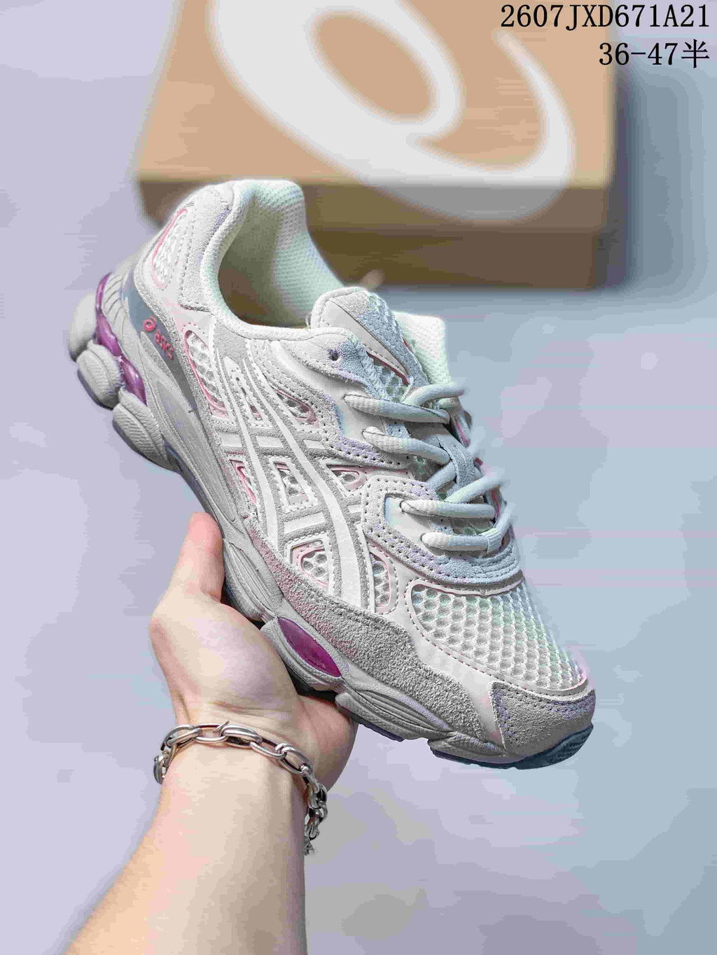 White ASICS GEL-Kayano 14 sneaker with pink and purple accents.
