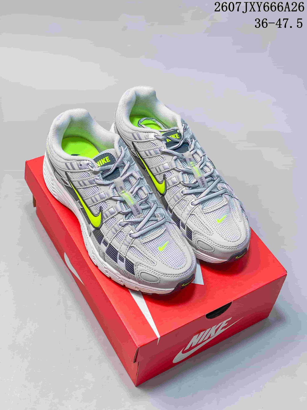 Pair of grey and volt Nike P-6000 sneakers displayed on a red Nike shoe box.