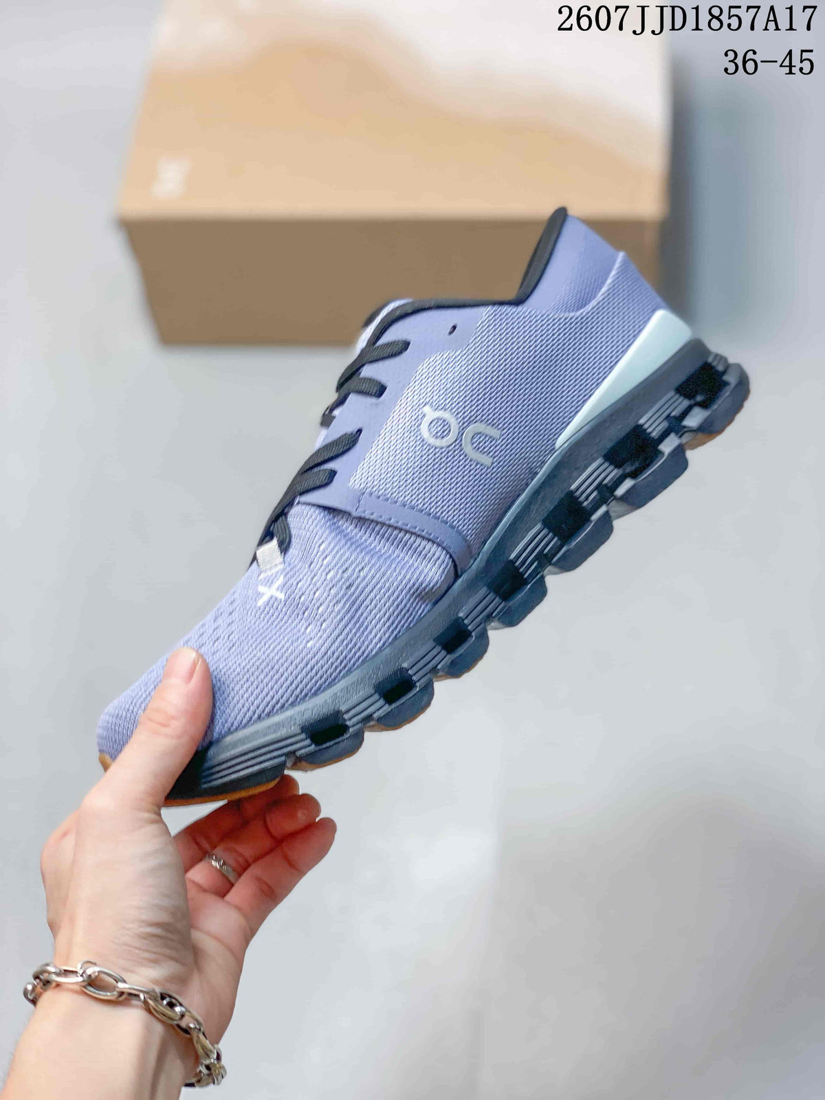 Side profile of the lavender-grey low-top sneaker showing the knit-style upper, On branding, black sole structure, and tan toe outsole section.