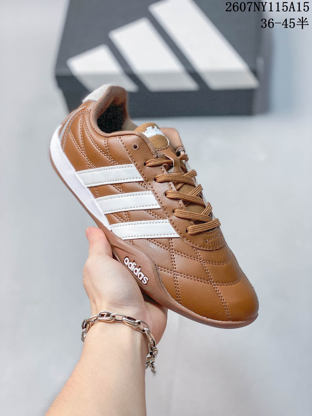 Angled side view of the brown sneaker with white stripes, stitched upper, and low-profile sole.