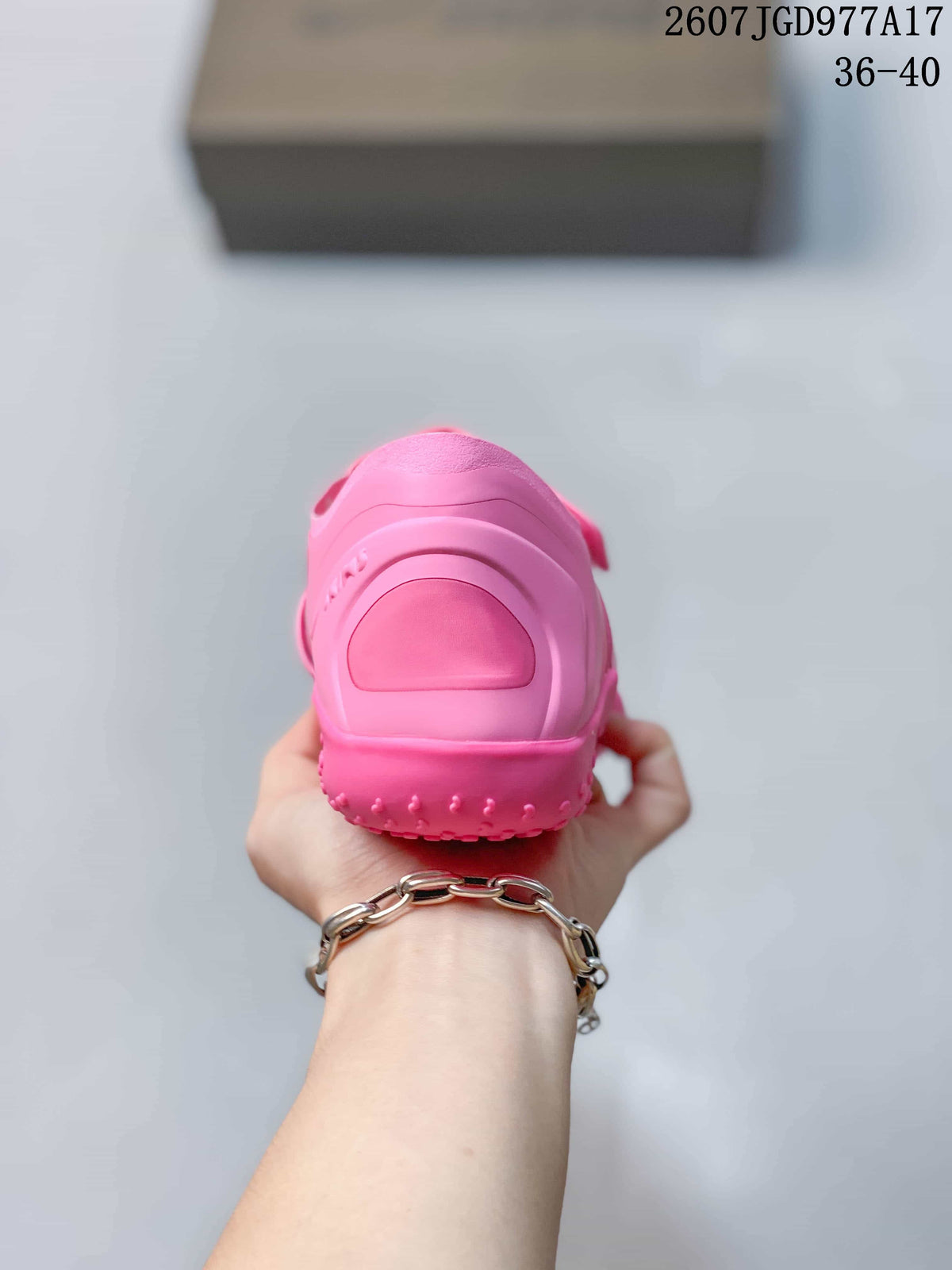 Rear view of the pink sneaker showing the rounded heel structure and textured outsole edge.