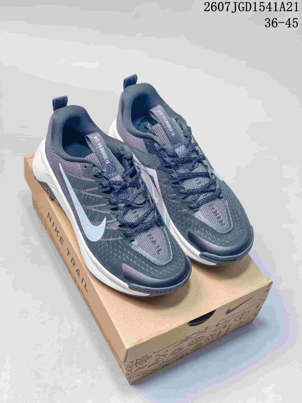 Pair of dark gray Nike Wildhorse 10 sneakers displayed on a Nike shoebox, with white midsoles and muted purple accents.