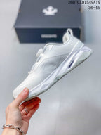 Side view of the white low-top sneaker showing the layered upper and sculpted midsole.